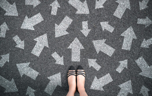 Feet and arrows on road background. Woman standing with many direction sign arrow choices in different ways, left and forward. Taking decisions for the future female. Top view of selfie foot and shoe.